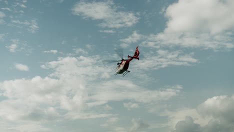 helicóptero de rescate volando en el cielo azul con nubes blancas - slowotion