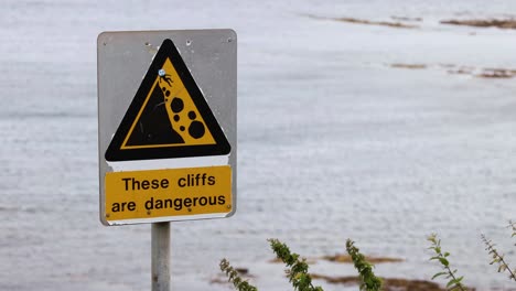 warning sign near cliffs in fife, scotland