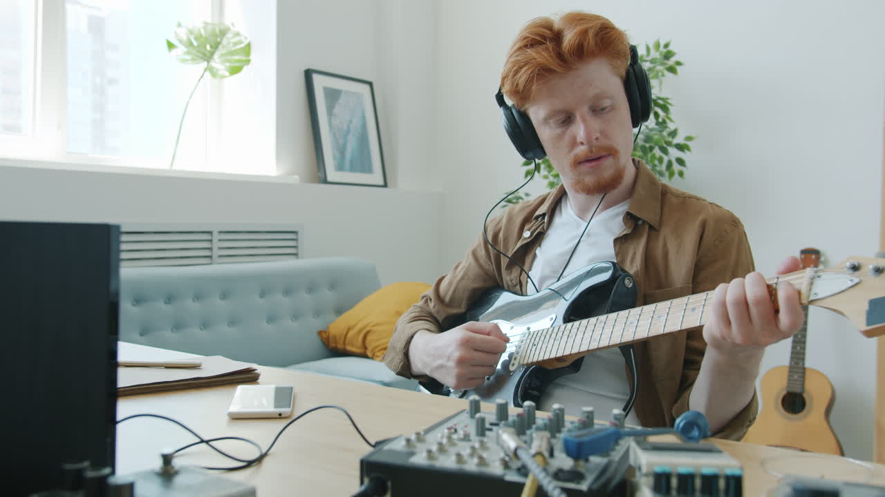 가정 스튜디오에서 전기 기타를 연주하는 남자