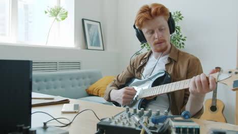 hombre tocando la guitarra eléctrica en el estudio casero