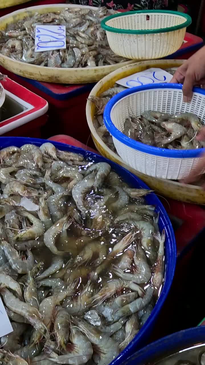 persona que selecciona camarones de varias cestas