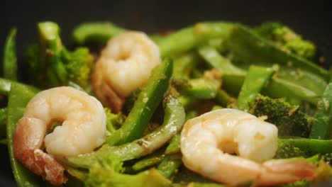 unrecognizable person putting stir fried prawns