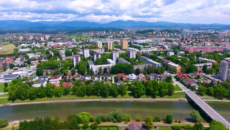 drone panorámico aéreo filmado sobre celje ciudad verde eslovena a lo largo del río savinja durante un soleado día de verano, barrio limpio y pacífico