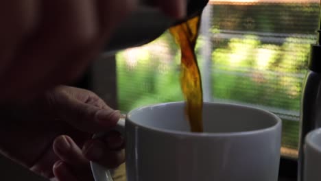 Woman-pouring-coffee-into-a-cup-from-a-stainless-steel-thermoflask