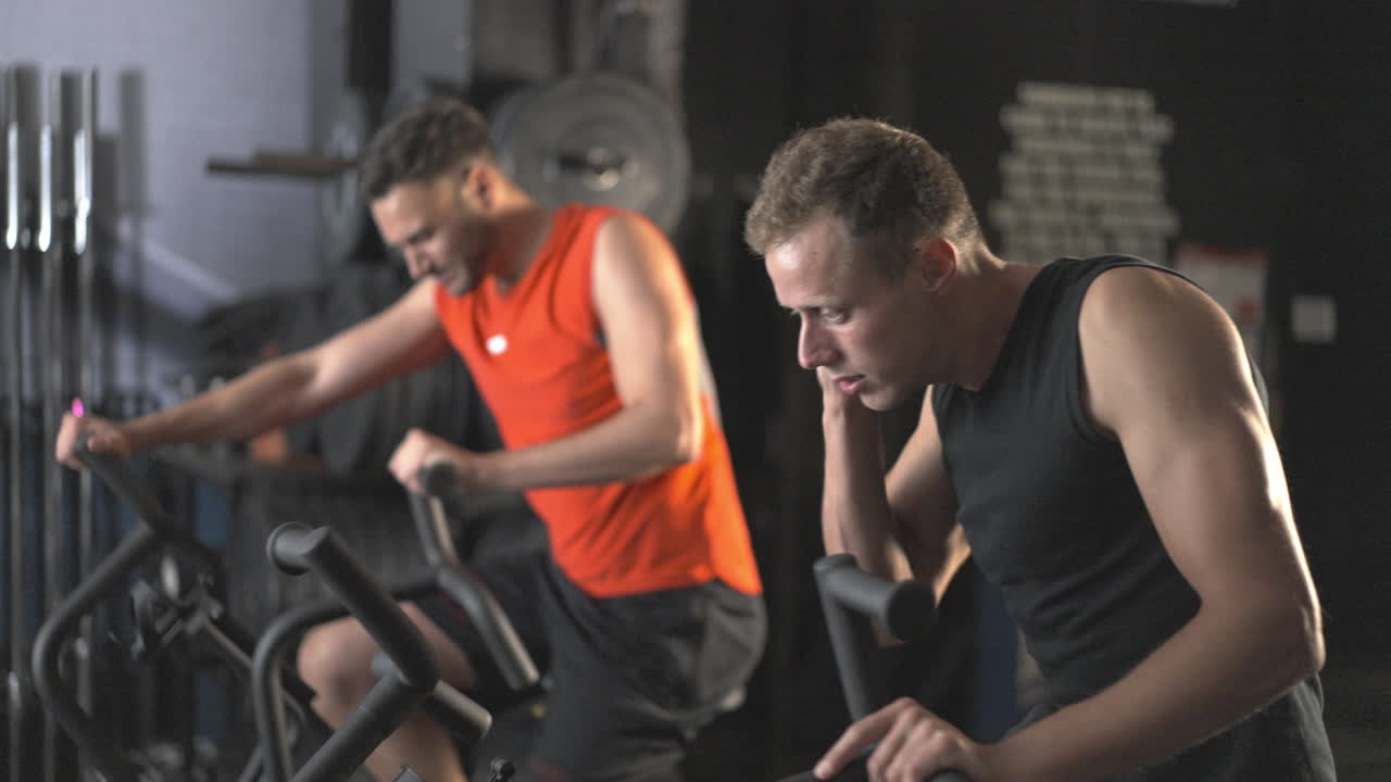 Men working out on exercise bikes in a gym