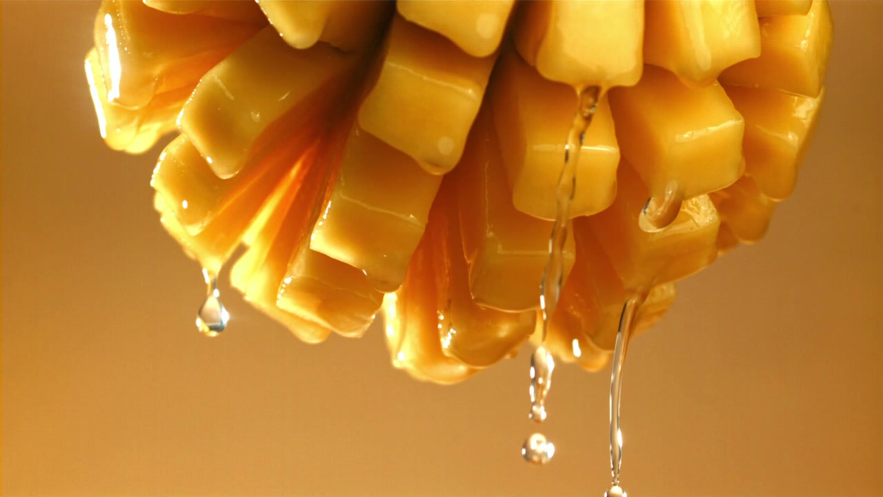 Gocce d'acqua al rallentatore da cubetti di mango fresco.