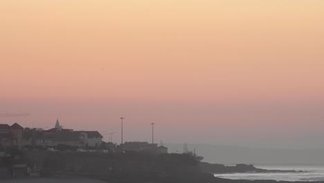 Beautiful-skyline-with-some-cars-driving-in-Lisbon,-orange-sky-over-the-land-in-view