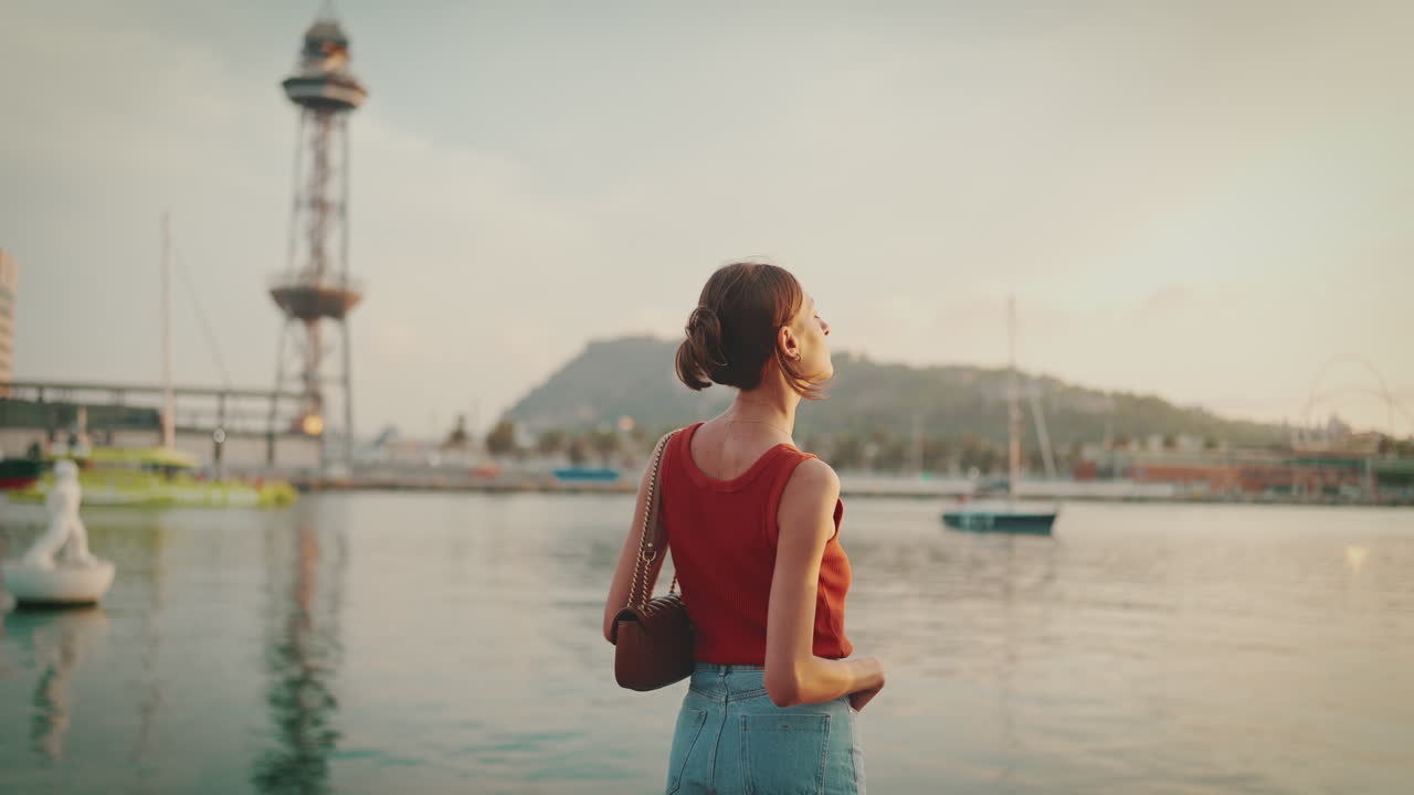 Woman overlooking a cityscape at sunset