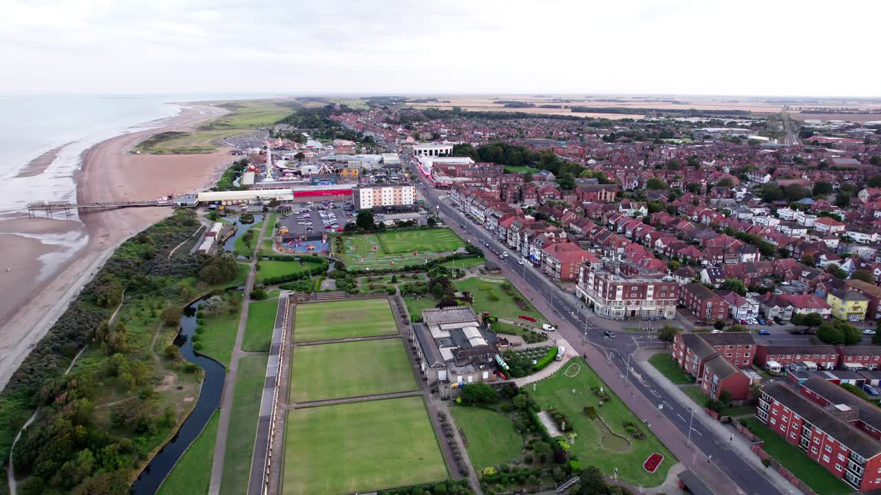 por encima de la ciudad, las imágenes de video revelan el encanto de una puesta de sol sobre skegness, una ciudad costera en el reino unido, con la ciudad, el paseo marítimo, el muelle y la impresionante costa