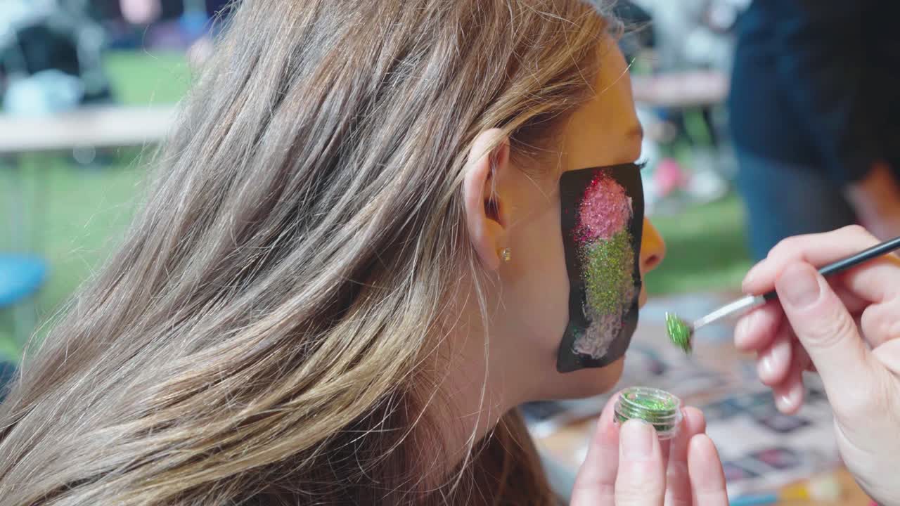 십대 소녀는 얼굴에 꽃의 임시 반 ⁇ 이는 문신을 가지고 있습니다.