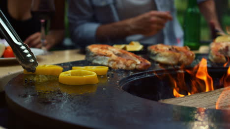 unrecognizable man cooking outside. chef putting onion and pepper on grill