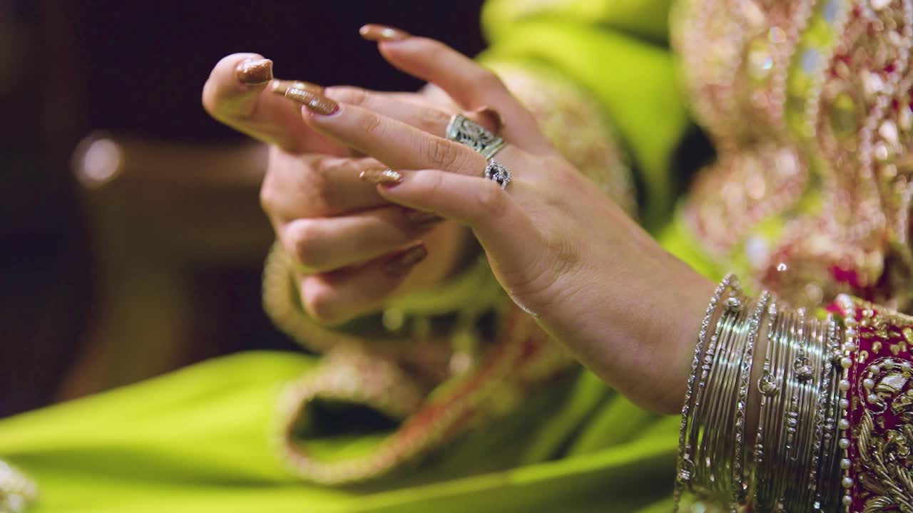 An up-close view of the ring-studded hands of an Asian bride in costume