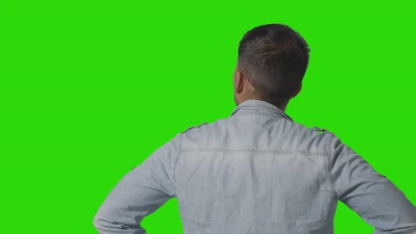 estudio, vista trasera, de, casualmente, vestido, joven, mirar, pantalla verde