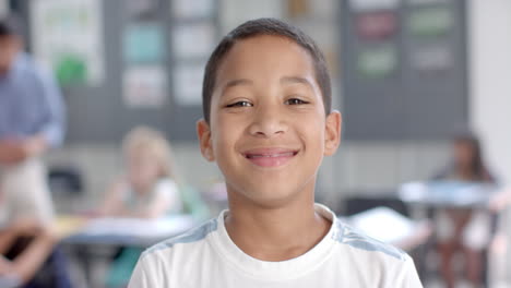 biracial boy smiles brightly in a classroom setting at school