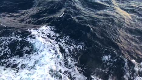 filming big waves from a boat in the sea in bali, indonesia