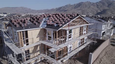 With-a-close-inspection,-a-drone-reveals-the-details-of-a-partially-built-house-on-a-construction-site,-providing-a-nuanced-view-of-the-ongoing-progress-in-residential-development