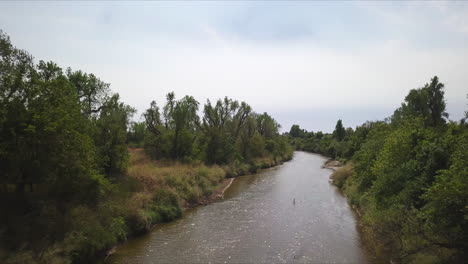 Toma-Aérea-De-Un-Pequeño-Río-Con-Agua-Marrón-De-Una-Fuerte-Lluvia