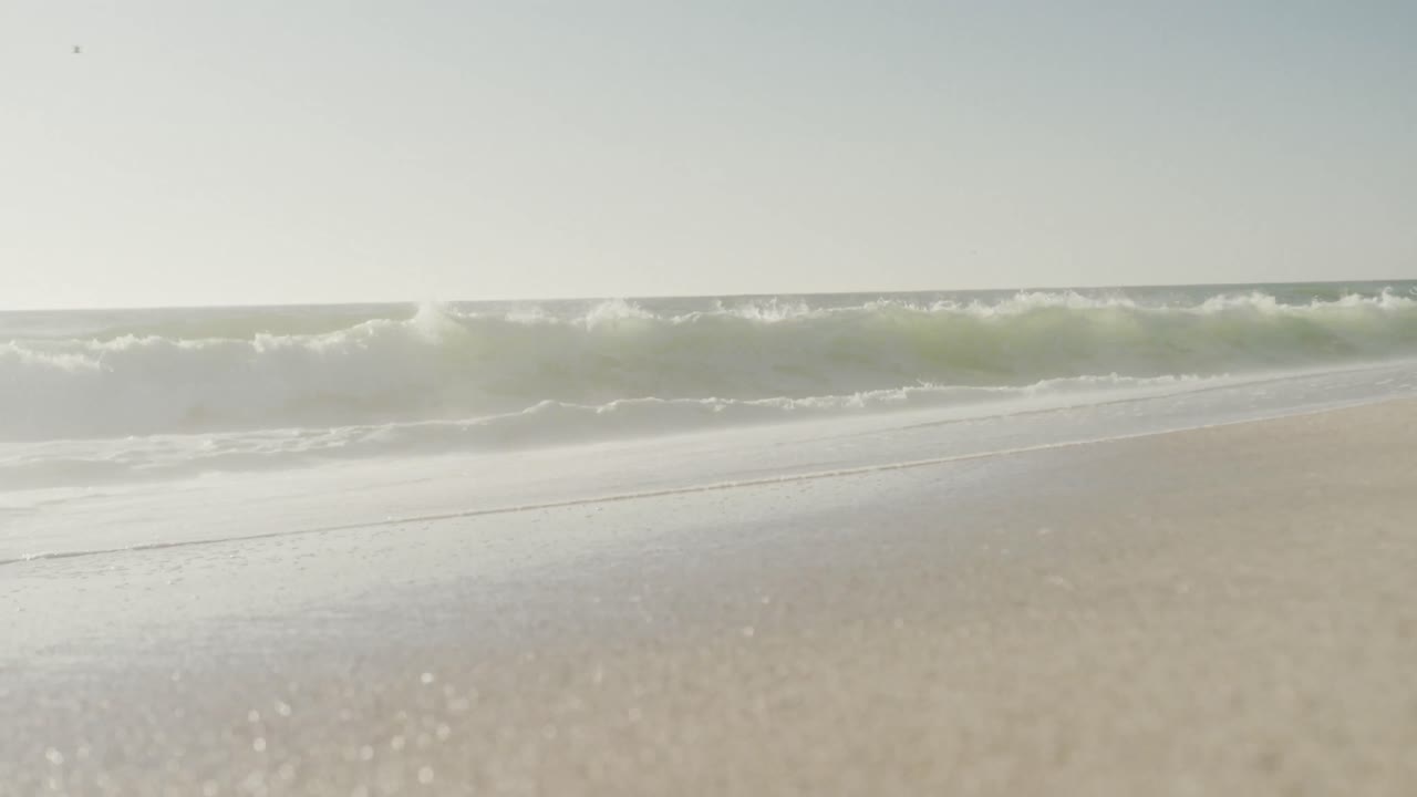 파란 하늘과 바다는 비어 있고  ⁇ 은 해변에 파도가 있습니다.