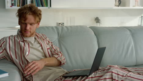 Businessman-studying-webinar-home-in-pajamas-closeup.-Focused-student-make-notes