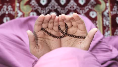 child praying with prayer beads