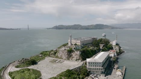 aerial rotating shot of alcatraz prison island with golden gate bridge in background in san francisco, ca