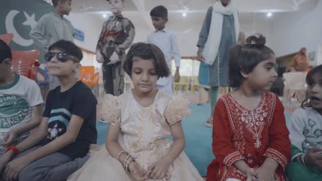 selective focus on small girls sitting on ground and celebrating 14 august independence day in pakistan.