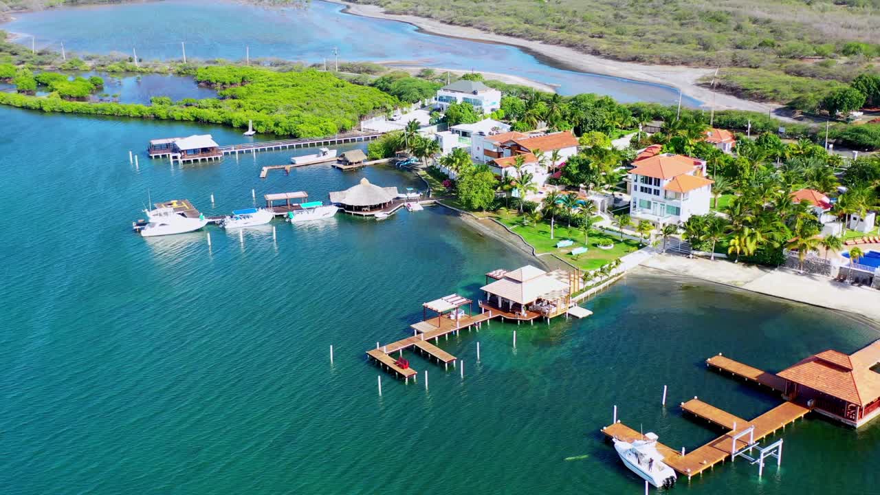 Aerial circling above Las Calderas Bani bay and marina with boats moored at jetty