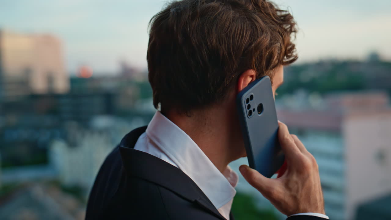 Elegant executive talking mobile phone standing office building terrace closeup