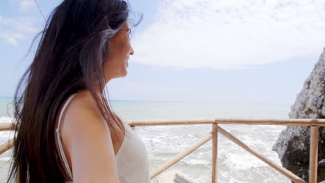 brunette woman taking self portrait by ocean