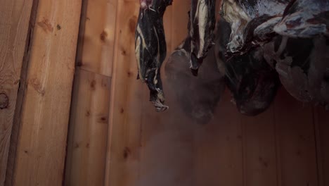 cold smoking deer meat inside wooden smokehouse