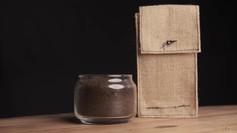 ground coffee in a glass jar and burlap bag