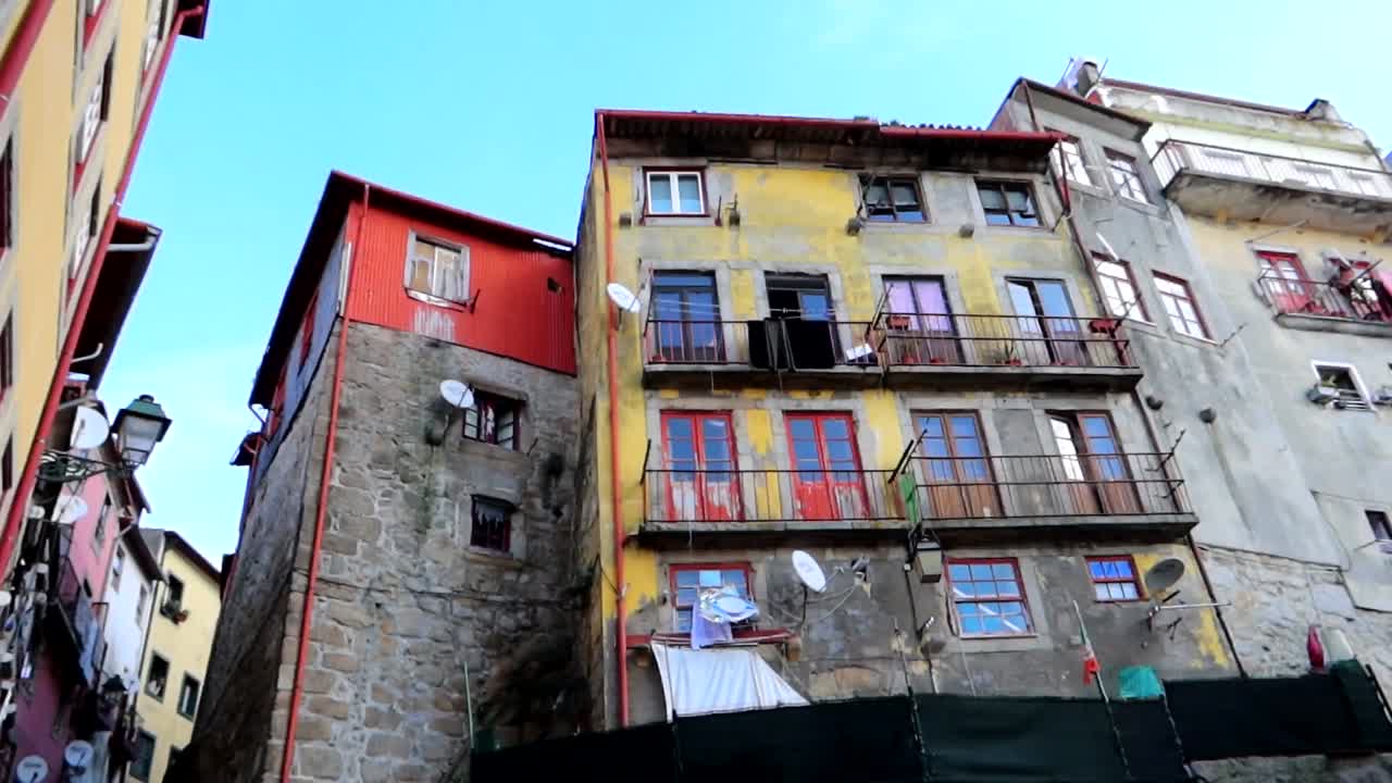 paredes de colores desgastados y balcones de fachada pintados de largo da pena ventosa en porto, portugal