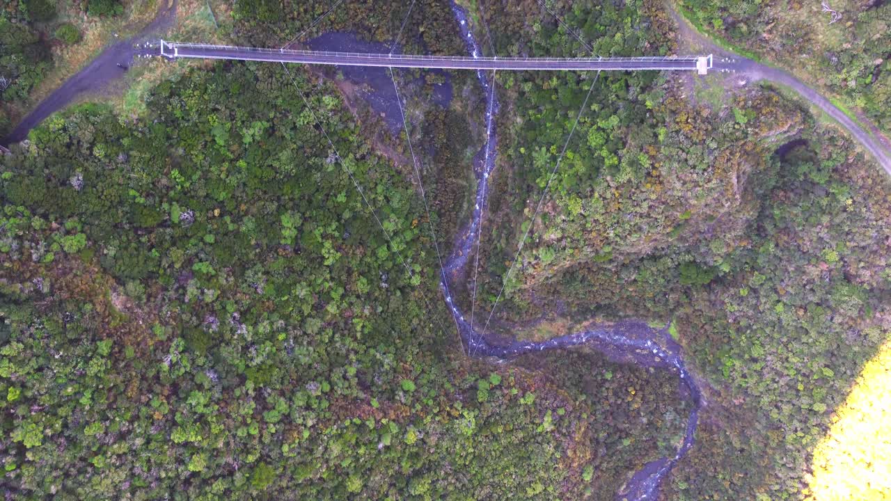 vista a vista de pájaro, volando sobre un gran puente colgante con un río debajo