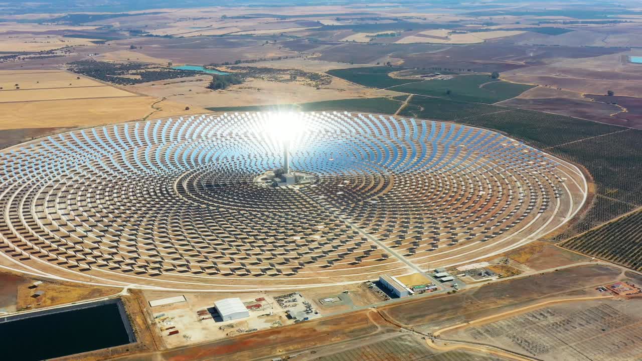 vista aérea con un dron de una planta solar térmica grande y circular utiliza espejos que enfocan los rayos solares en una torre de recolección para producir energía renovable y libre de contaminación - concepto ambiental