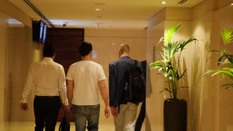 men walking in hotel hallway/corridor