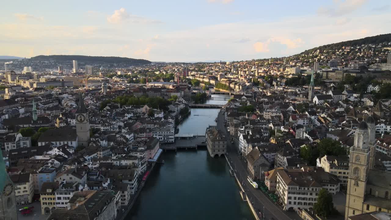 drone disparado volando hacia la ciudad de zúrich, suiza, al atardecer.