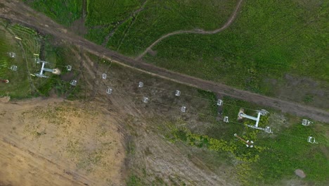 aerial top down overview of ski chair lift static unmoving over grassy green hillside in summer