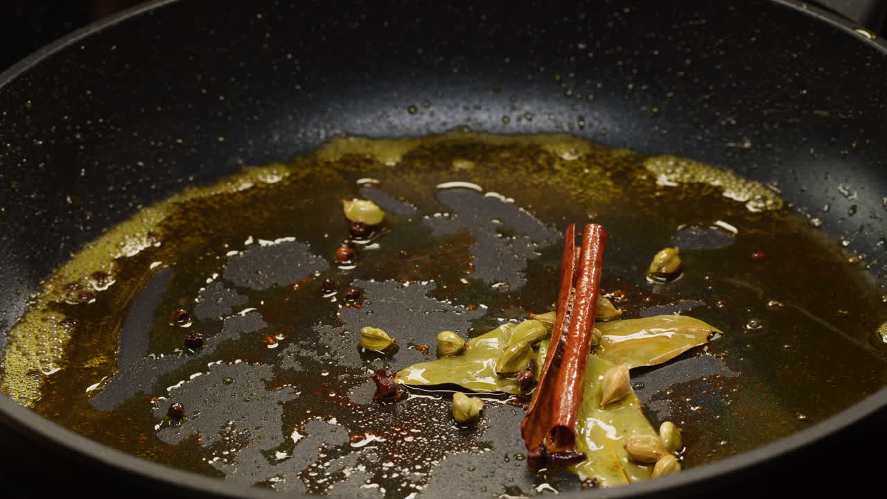 Cooking red onion with spices in a frying pan