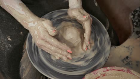 a woman potter makes dishes from clay. a woman makes a jug on a potter's wheel