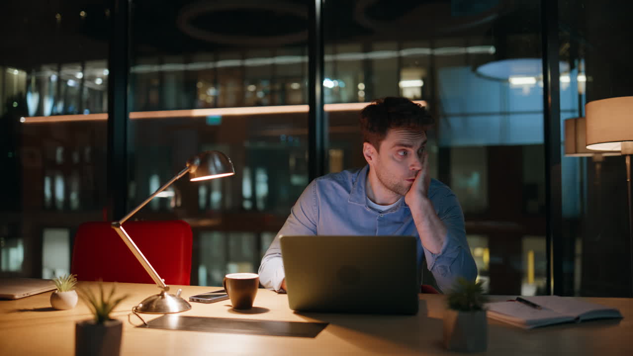 Overworked manager browsing laptop at night workspace. Tired businessman burnout