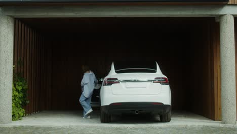 woman charging electric car in garage