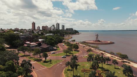 Dron-Avanzando-Sobre-La-Avenida-Costanera-De-Posadas,-Mostrando-Monumentos-Y-El-Horizonte-De-La-Ciudad