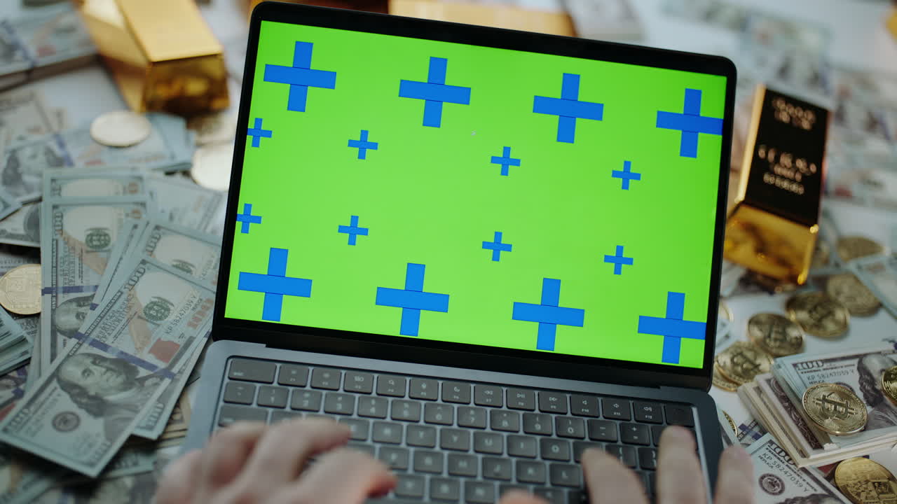 Laptop surrounded by money and gold