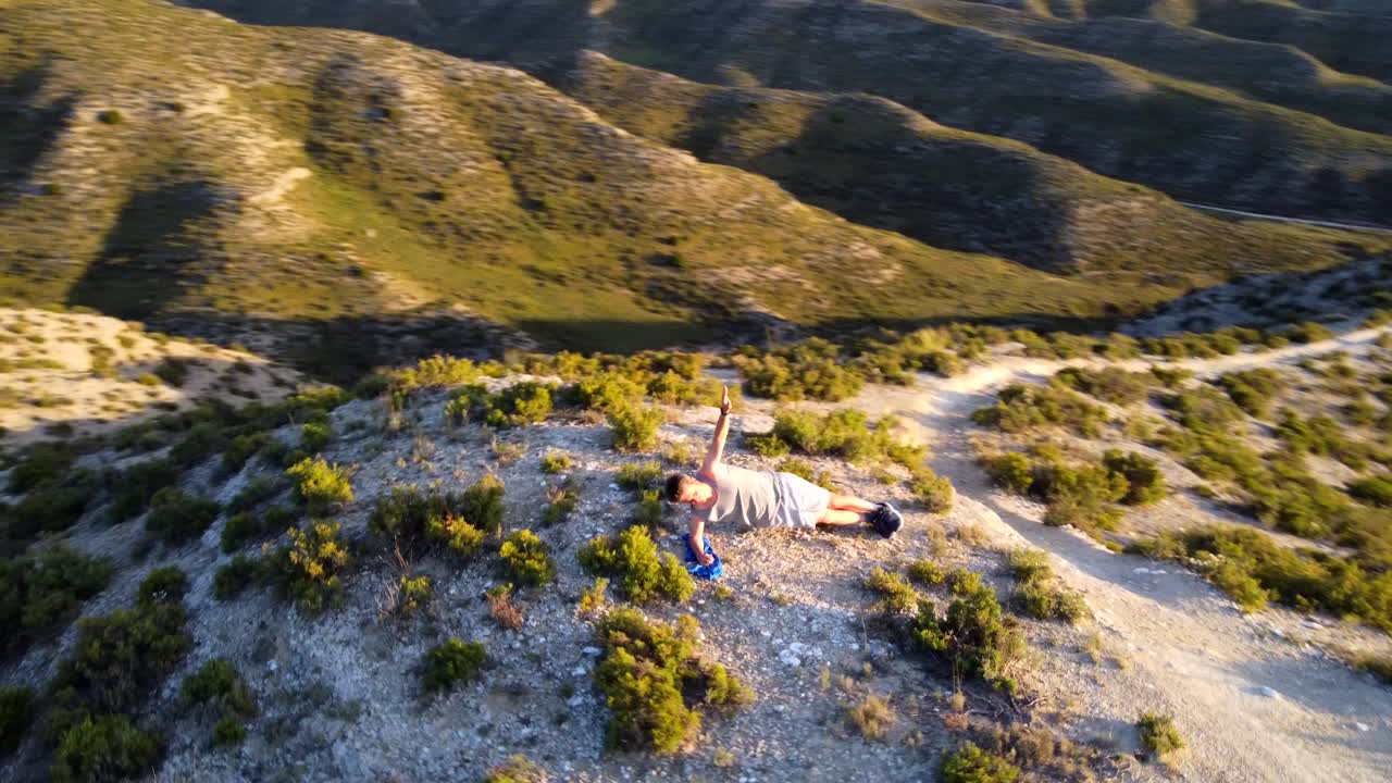 체조를 하는 남자의 공중 촬영은 덤불 속에서 야외에서 움직인다