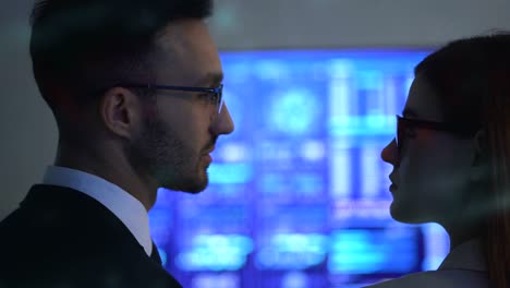 the business couple talking near the blue display