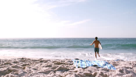 a man is running with his surfboard