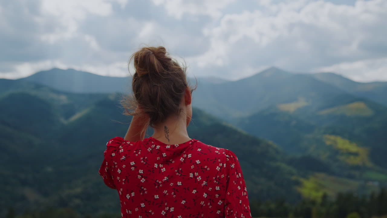 Unknown woman enjoying mountains landscape close up. Back view girl standing.