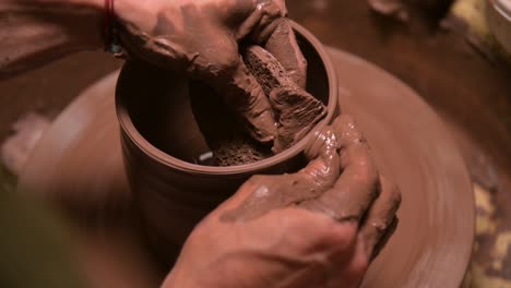 close-up of male hands making a clay bowl on a potter's wheel. handicraft and production of exclusive tea ware made of clay