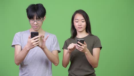 young asian couple using phone together