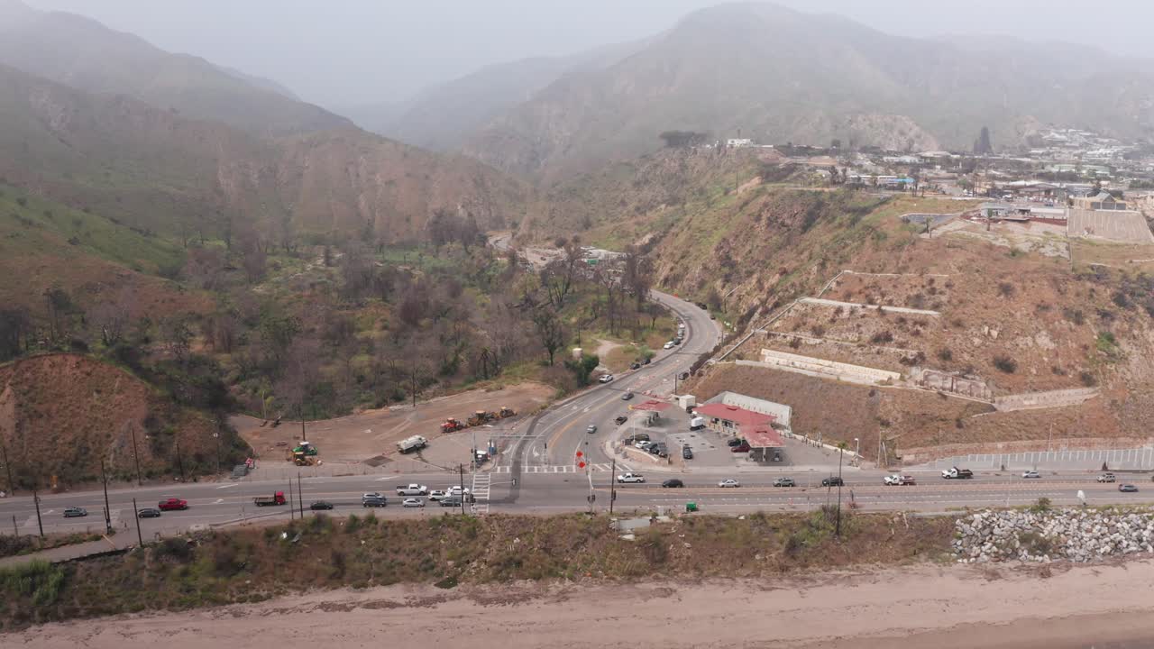 Aerial descending close-up shot of the intersection of Pacific Coast Highway and Topanga Canyon after the Palisades Fire in Southern California. 4K